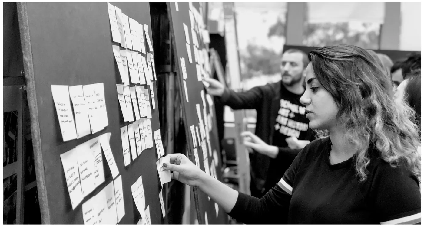 Participants clustering sticky notes on a wall during a Passbook participatory design workshop.